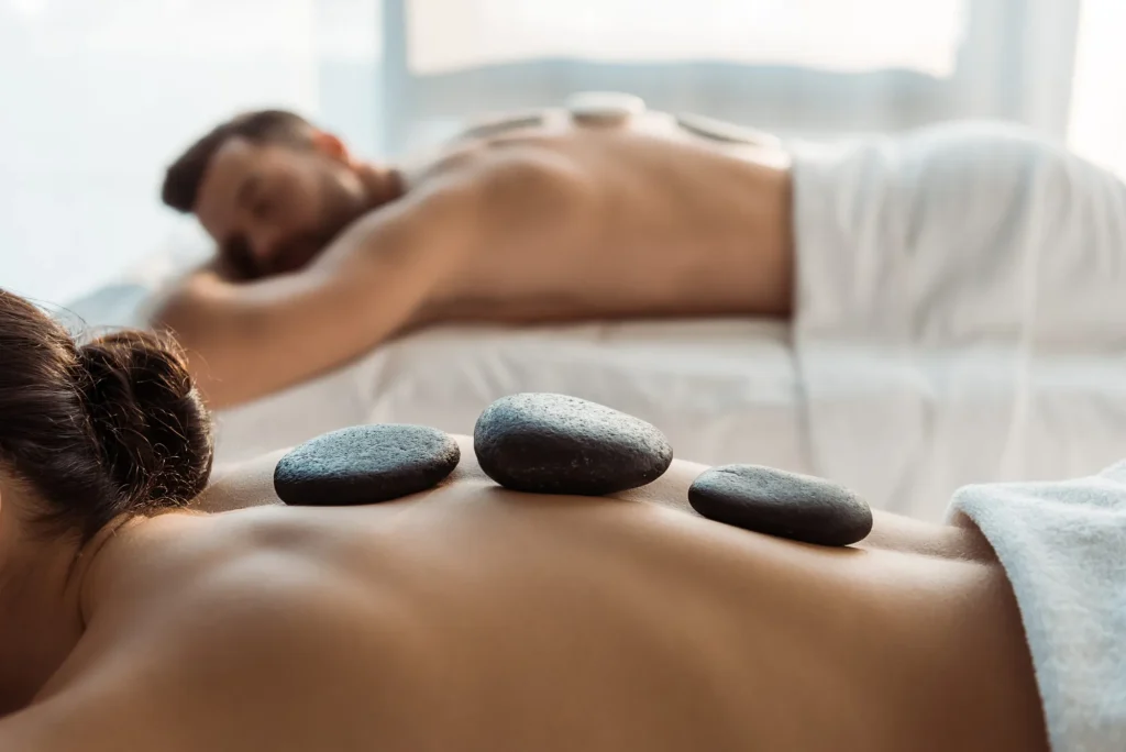 selective focus of woman having stone massage near man in spa center