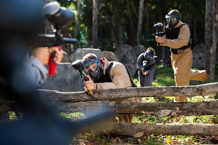 Portrait of team of adults playing on paintball battlefield outdoor